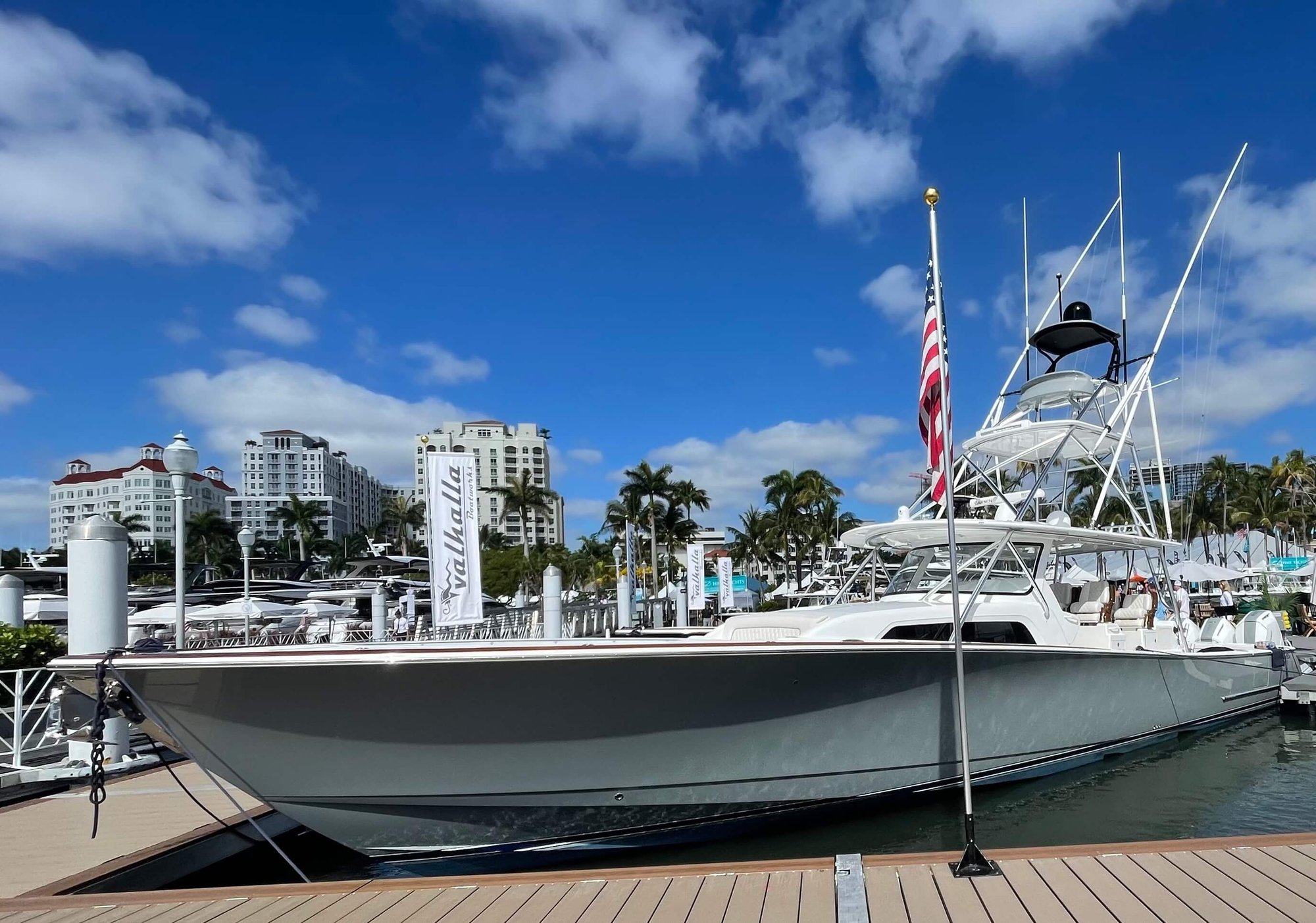 Large yacht fishing boat docked at a marina with a city scape in the background. | boat delivery services