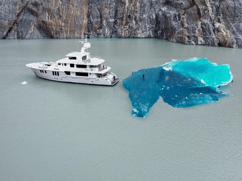 Yacht near a rock mountain and ice.