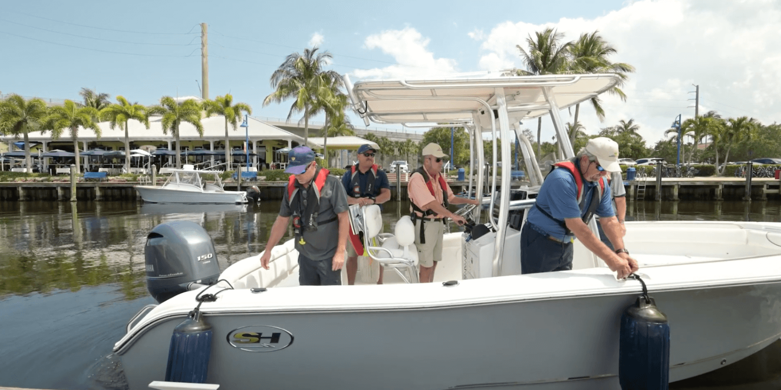Boat leaving marina with 5 passengers in life jackets for training.