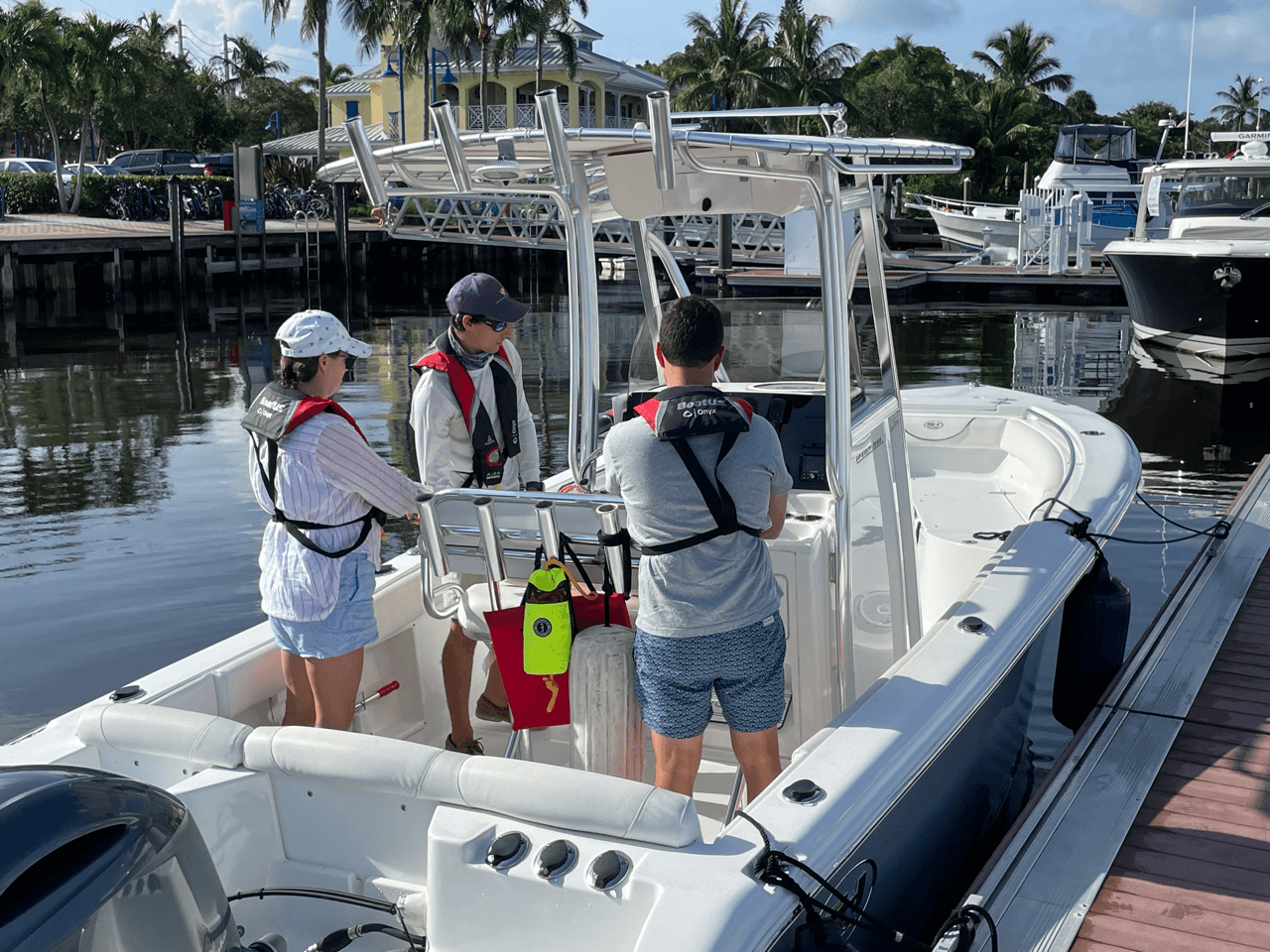 At The Helm Training lesson on a boat with three people in life jackets